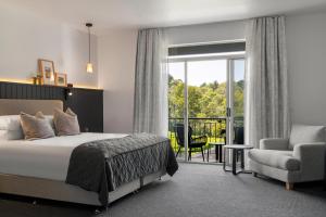 a bedroom with a bed and a chair and a window at Mantons Creek Estate in Shoreham