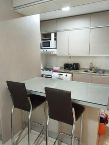 a kitchen with a table and two chairs at Alojamiento Premium en Pichincha in Laprida +5 photos