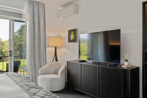 a bedroom with a tv and a chair and a bed at Mantons Creek Estate in Shoreham