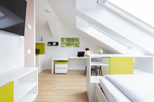 an attic office with a desk in a room at Candlewood Suites Fürth by IHG in Fürth