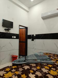 a room with a bed with a comforter and a television at Hotel Sudha Palace in Khātu