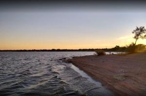 a body of water with the sunset in the background at Ranchette Apartment- beach access small lake view in Buchanan Dam +36 photos