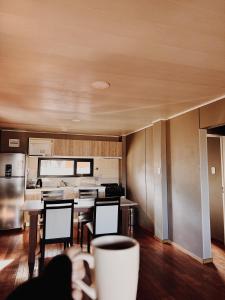 a person holding a cup of coffee in a kitchen at Cabañas Lihuen in Caviahue