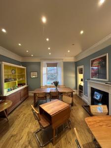 a dining room with tables and chairs and a fireplace at The Cruachan Stoer in Stoer