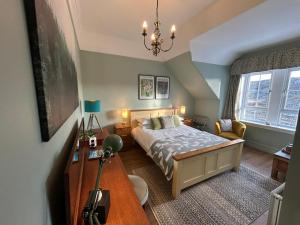 a bedroom with a bed and a table and a window at The Cruachan Stoer in Stoer