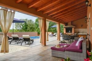 an outdoor patio with a couch and chairs and a table at Villa Percan - Spacious Family Home with Private Pool on a 4000 Square Meter Plot in Krnica