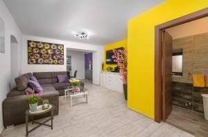 a living room with a couch and a yellow wall at Villa Percan - Spacious Family Home with Private Pool on a 4000 Square Meter Plot in Krnica