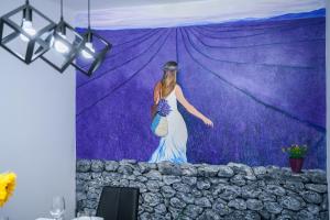 a mural of a woman standing in front of a purple wall at Villa Percan - Spacious Family Home with Private Pool on a 4000 Square Meter Plot in Krnica +37 photos