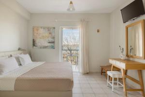 a bedroom with a bed and a desk and a window at Panorama Fanari studios and apartments in Argostoli +157 photos