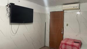 a flat screen tv on the wall of a bathroom at Pousada Rosario in Malhada dos Bois