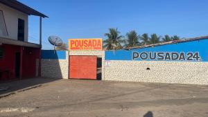 a building with a red door and a sign on it at Pousada Rosario in Malhada dos Bois
