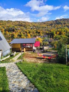 a view of a park with a building and trees at Carpatina A-Frame Retreat - Rustic Cabins for Couples in Runcu