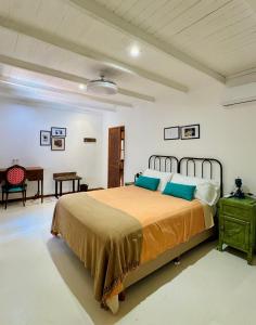 a bedroom with a large bed and a table at Rincón Escondido B&B in Puerto Iguazú