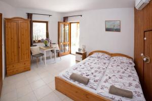 a bedroom with a bed and a room with a desk at Vicze Apartmanház in Siófok