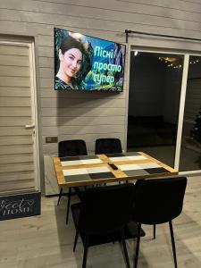 a table with chairs and a tv hanging on a wall at Gora vitriv in Slavske