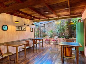 a restaurant with tables and chairs in a room at Rincón Escondido B&B in Puerto Iguazú
