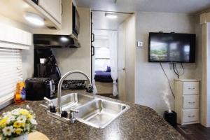 a kitchen with a sink and a tv on the wall at Sun RV in Trailer park in Naples