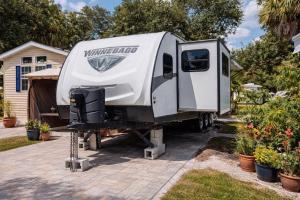a white truck with a camper parked in a driveway at Sun RV in Trailer park in Naples
