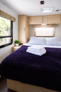 a bedroom with a purple bed with towels on it at Sun RV in Trailer park in Naples