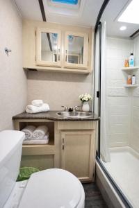 a bathroom with a toilet and a sink and a tub at Sun RV in Trailer park in Naples