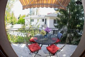 a glass table and chairs on a balcony at Vicze Apartmanház in Siófok