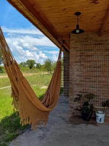 a hammock hanging from a porch with a field at Casa Uno in Paso de la Patria