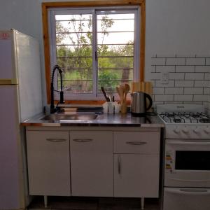 a kitchen with a sink and a stove and a window at Casa Uno in Paso de la Patria +3 photos