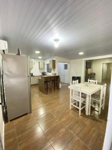 a kitchen with a white table and a refrigerator at Casa central in Rosário do Sul