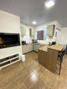 a large kitchen with a large flat screen tv at Casa central in Rosário do Sul