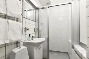 La salle de bains est pourvue de toilettes, d'un lavabo et d'une douche. dans l'établissement Hotel Bema, à Stockholm