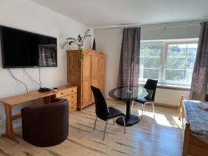 a living room with a table and chairs and a television at Byron in Zlaté Moravce