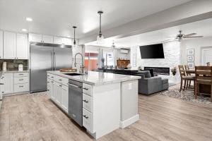 a kitchen with white cabinets and a living room at Timberland Hideaway in Payson