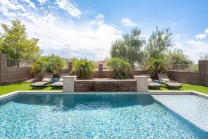 a swimming pool with chaises and chairs in a backyard at Superstition Sunrise in Gold Canyon