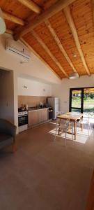 a living room with a table and a kitchen at Casa de Campo Roca - Exclusivo para Parejas in Villa Cura Brochero +15 photos