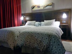 1 dormitorio con 1 cama grande y cortinas rojas en La Majada de la Covatilla, en La Hoya