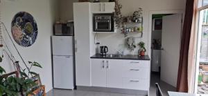 a kitchen with white refrigerators and a sink at Private cabin in Whitianga +7 photos