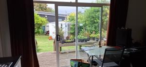 an open sliding glass door with a view of a garden at Private cabin in Whitianga