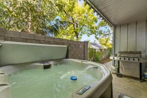 a hot tub in a backyard with a grill at High Pines Abode in Flagstaff