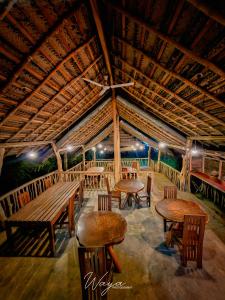 a room with wooden tables and chairs and a roof at Elephant paradise Safari lodge in Udawalawe