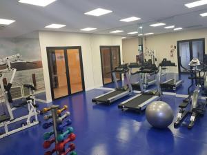 a gym with treadmills and machines in a room at Flat Novo1 - Café, Cama Queen, Ar, Estac e Internet in Barueri