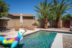 a swimming pool with a inflatable pool noodle in a backyard at The Seaside Bohemian in Chandler