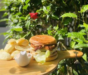 a sandwich and chips on a cutting board with a flower at Simon's Place in Nuku‘alofa +10 photos