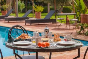 a table with food on it next to a pool at Dar Fatima Tamazouzt in Marrakesh