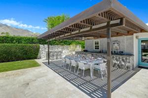 a patio with a table and chairs under a pavilion at Palm 57 - Alice Lodging in Palm Springs +52 photos