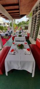 a row of tables with red chairs and flowers on them at Simon's Place in Nuku‘alofa