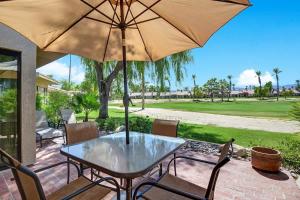 a table and chairs with an umbrella on a patio at PN561 - Jupiter View - Alice Lodging in Palm Desert