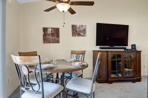a dining room table with chairs and a ceiling fan at PN561 - Jupiter View - Alice Lodging in Palm Desert