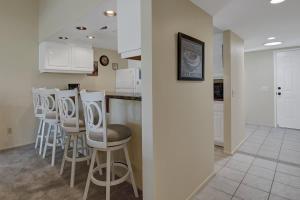 a kitchen with a row of stools and a bar at PN561 - Jupiter View - Alice Lodging in Palm Desert +28 photos