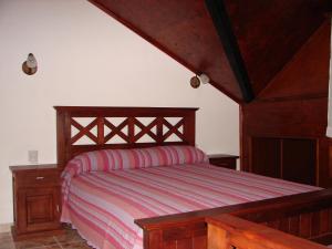 1 dormitorio con cama de madera con marco de madera en Cabañas Marias del Sur en El Calafate
