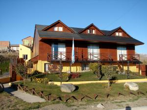 een groot houten huis met een zwart dak bij Cabañas Marias del Sur in El Calafate